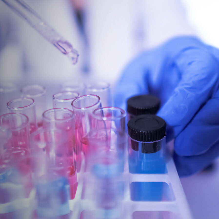 Liquid being pipetted into sample vials by lab worker